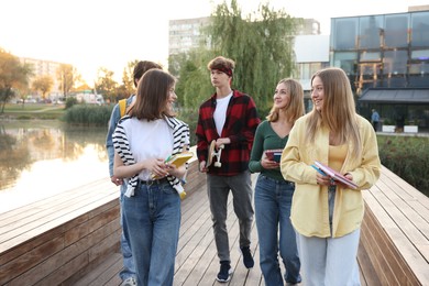 Photo of Group of teenagers walking near lake outdoors