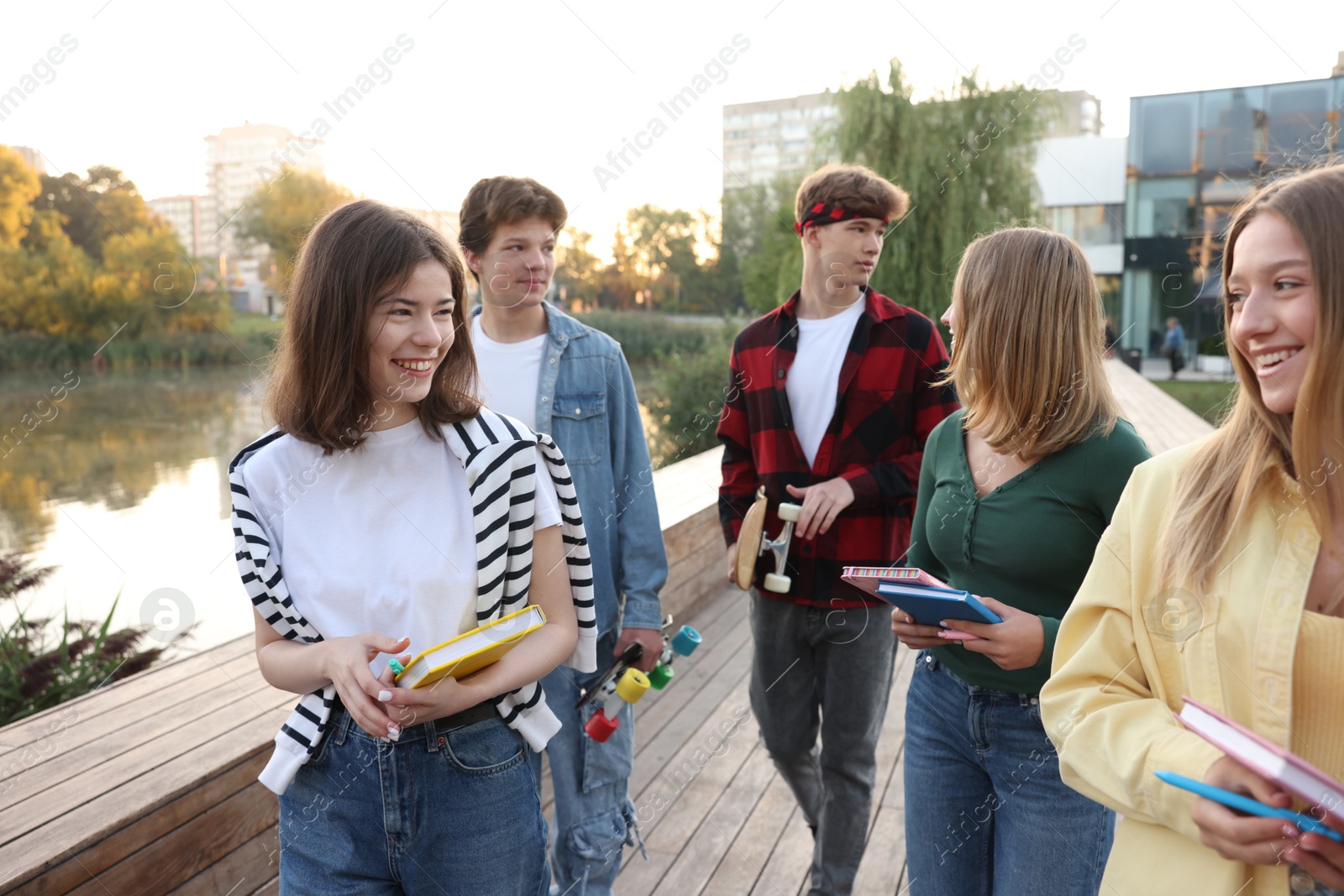 Photo of Group of teenagers walking near lake outdoors