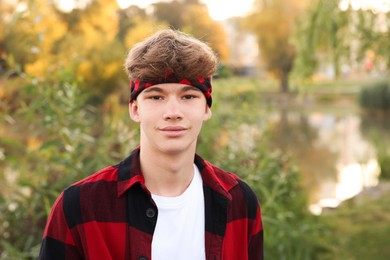 Photo of Portrait of teenage boy near lake outdoors, space for text