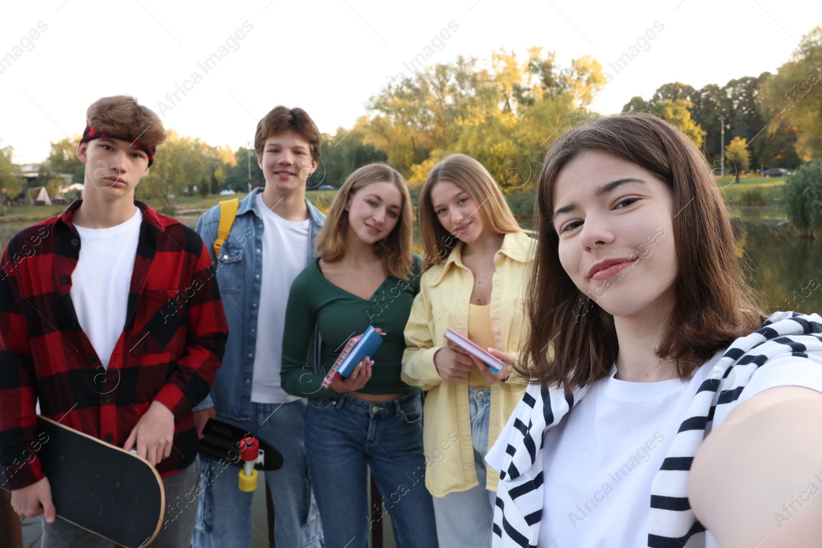 Photo of Group of teenagers taking selfie near lake outdoors