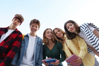 Photo of Portrait of teenagers under blue sky, low angle view