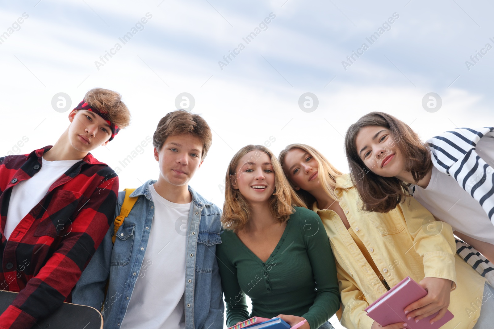 Photo of Portrait of teenagers under blue sky, low angle view