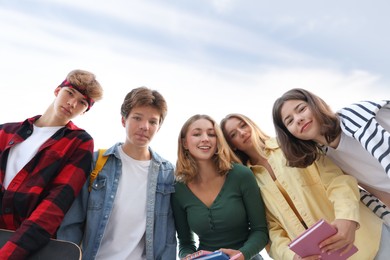 Photo of Portrait of teenagers under blue sky, low angle view