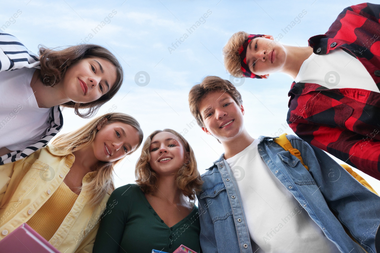 Photo of Portrait of teenagers under blue sky, low angle view
