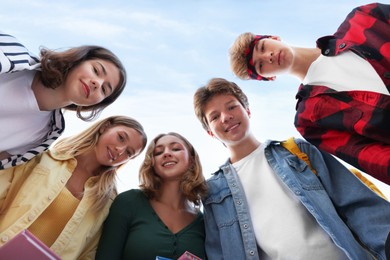 Photo of Portrait of teenagers under blue sky, low angle view