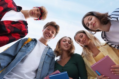 Photo of Portrait of teenagers under blue sky, low angle view