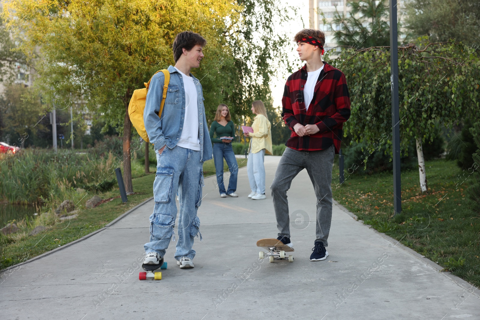 Photo of Group of teenagers walking on city street, selective focus