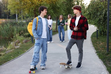 Photo of Group of teenagers walking on city street, selective focus