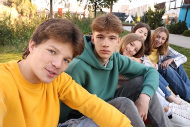 Photo of Group of teenagers taking selfie in park