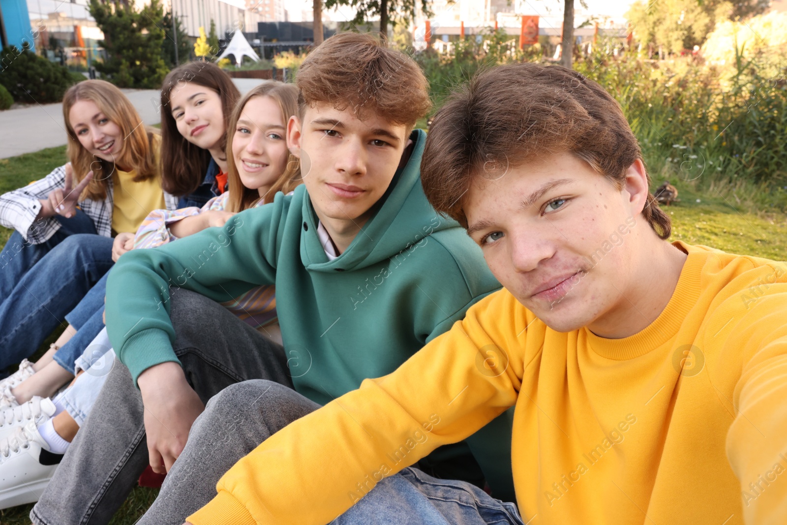 Photo of Group of teenagers taking selfie in park