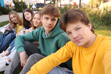 Photo of Group of teenagers taking selfie in park