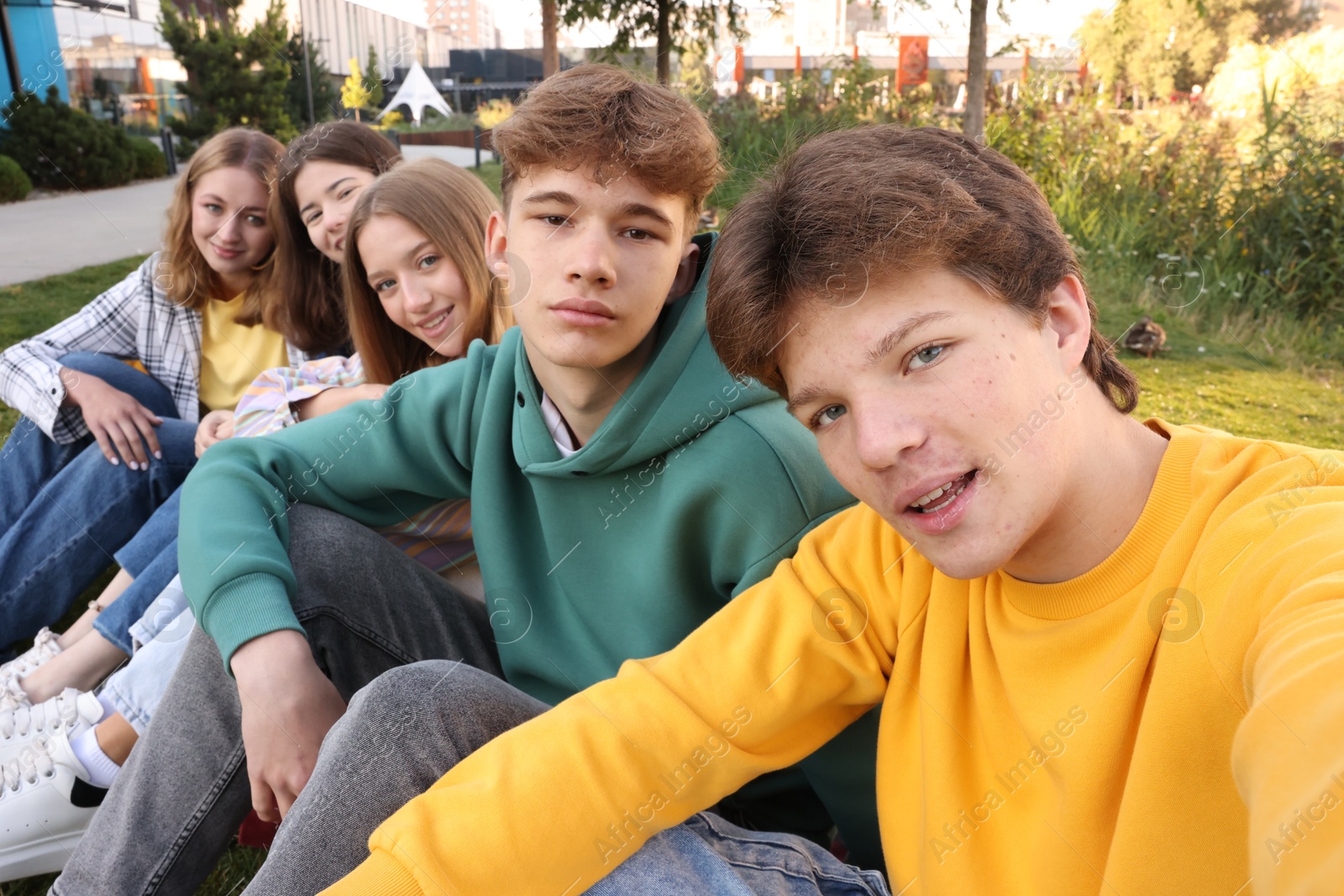 Photo of Group of teenagers taking selfie in park