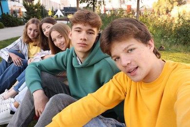 Photo of Group of teenagers taking selfie in park