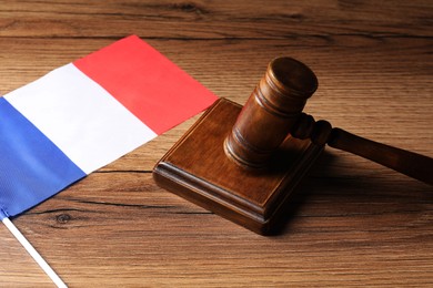 Photo of Judge's gavel and flag of France on wooden table