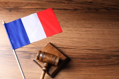 Photo of Judge's gavel and flag of France on wooden table, top view. Space for text
