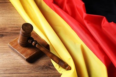 Photo of Judge's gavel and flag of Germany on wooden table