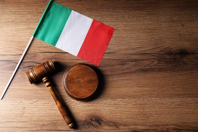 Photo of Judge's gavel and flag of Italy on wooden table, top view. Space for text
