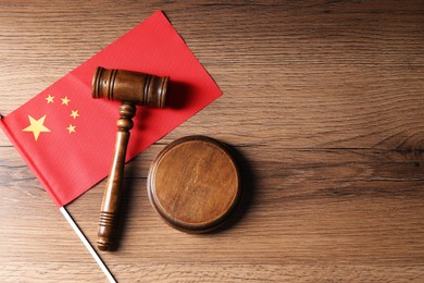 Photo of Judge's gavel and flag of China on wooden table, top view. Space for text
