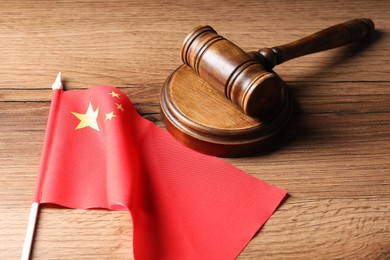 Photo of Judge's gavel and flag of China on wooden table