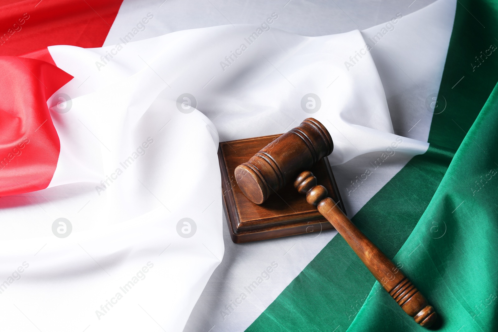 Photo of Wooden judge's gavel on flag of Italy