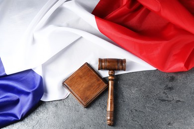 Photo of Judge's gavel and flag of France on grey table, top view