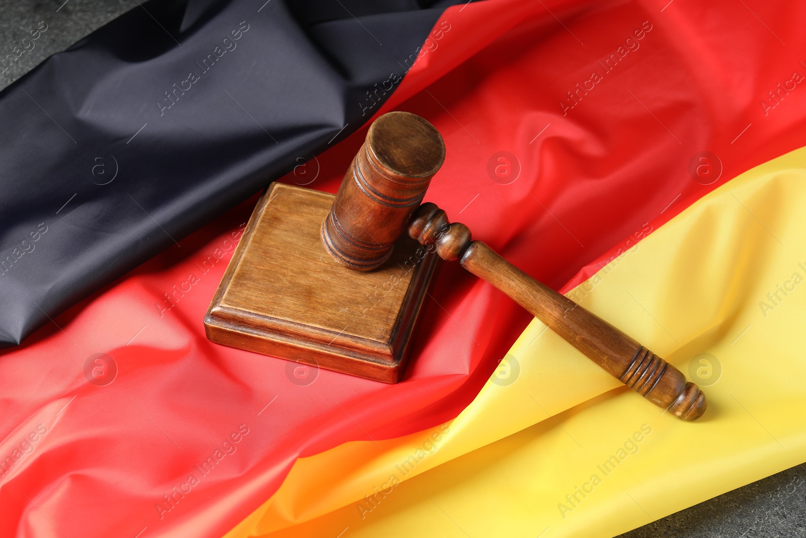 Photo of Judge's gavel and flag of Germany on grey table