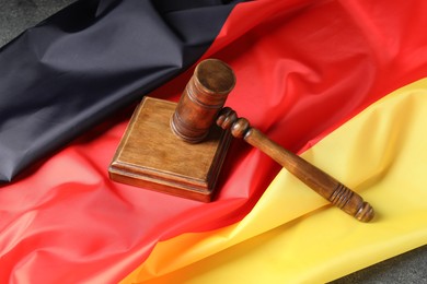 Photo of Judge's gavel and flag of Germany on grey table