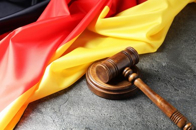 Photo of Judge's gavel and flag of Germany on grey table