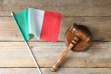 Photo of Judge's gavel and flag of Italy on wooden table, top view