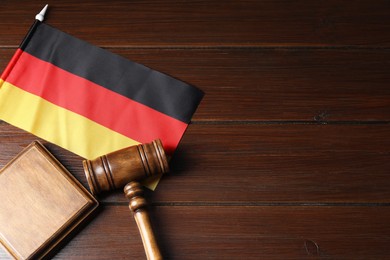 Photo of Judge's gavel and flag of German on wooden table, top view. Space for text