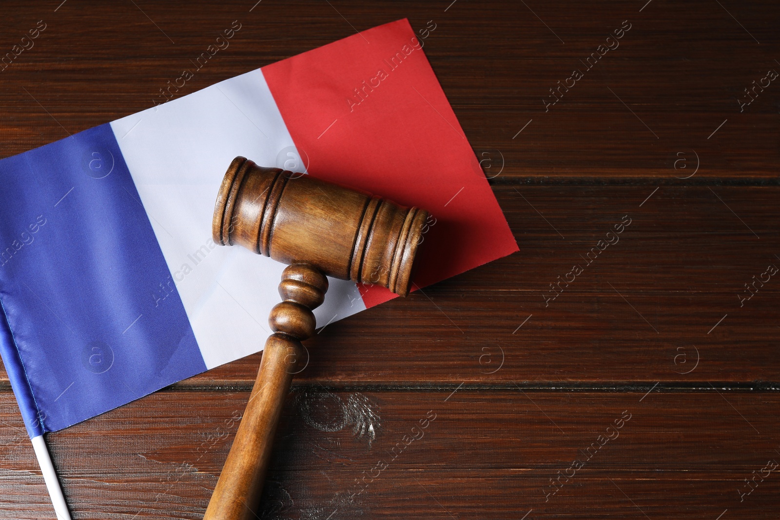 Photo of Judge's gavel and flag of France on wooden table, top view. Space for text