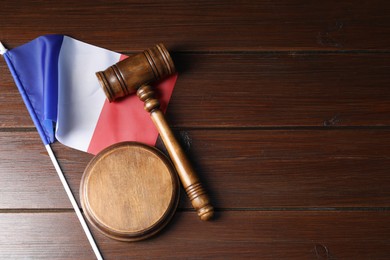 Photo of Judge's gavel and flag of France on wooden table, top view. Space for text