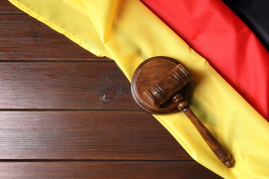 Photo of Judge's gavel and flag of Germany on wooden table, top view. Space for text
