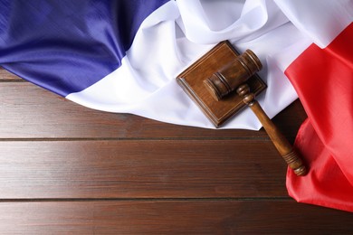 Photo of Judge's gavel and flag of France on wooden table, top view. Space for text