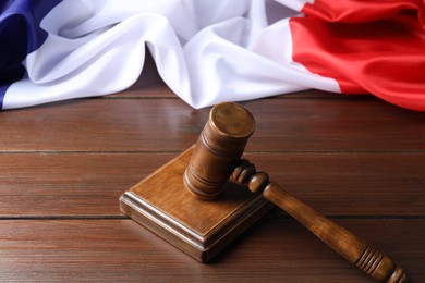 Photo of Judge's gavel and flag of France on wooden table