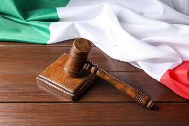 Photo of Judge's gavel and flag of Italy on wooden table