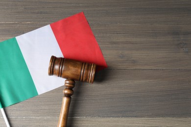 Photo of Judge's gavel and flag of Italy on wooden table, top view. Space for text