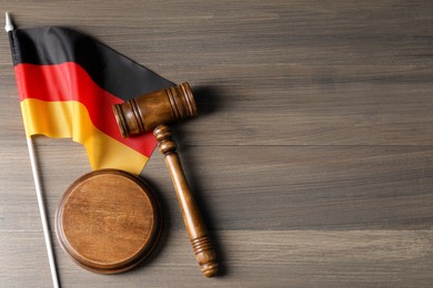 Photo of Judge's gavel and flag of Germany on wooden table, top view. Space for text