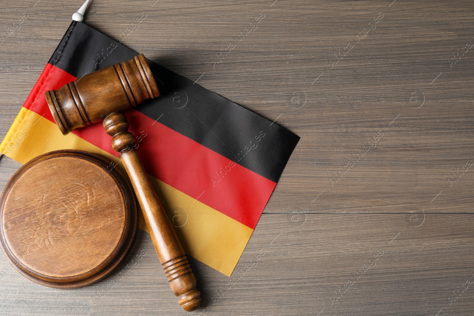Photo of Judge's gavel and flag of Germany on wooden table, top view. Space for text