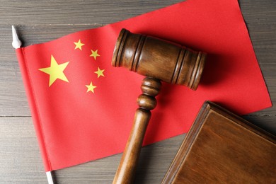 Photo of Judge's gavel and flag of China on wooden table, top view