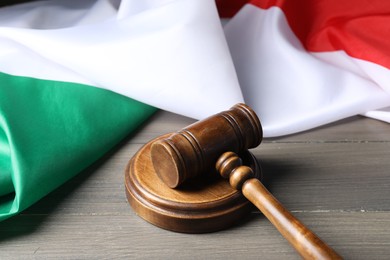 Photo of Judge's gavel and flag of Italy on wooden table