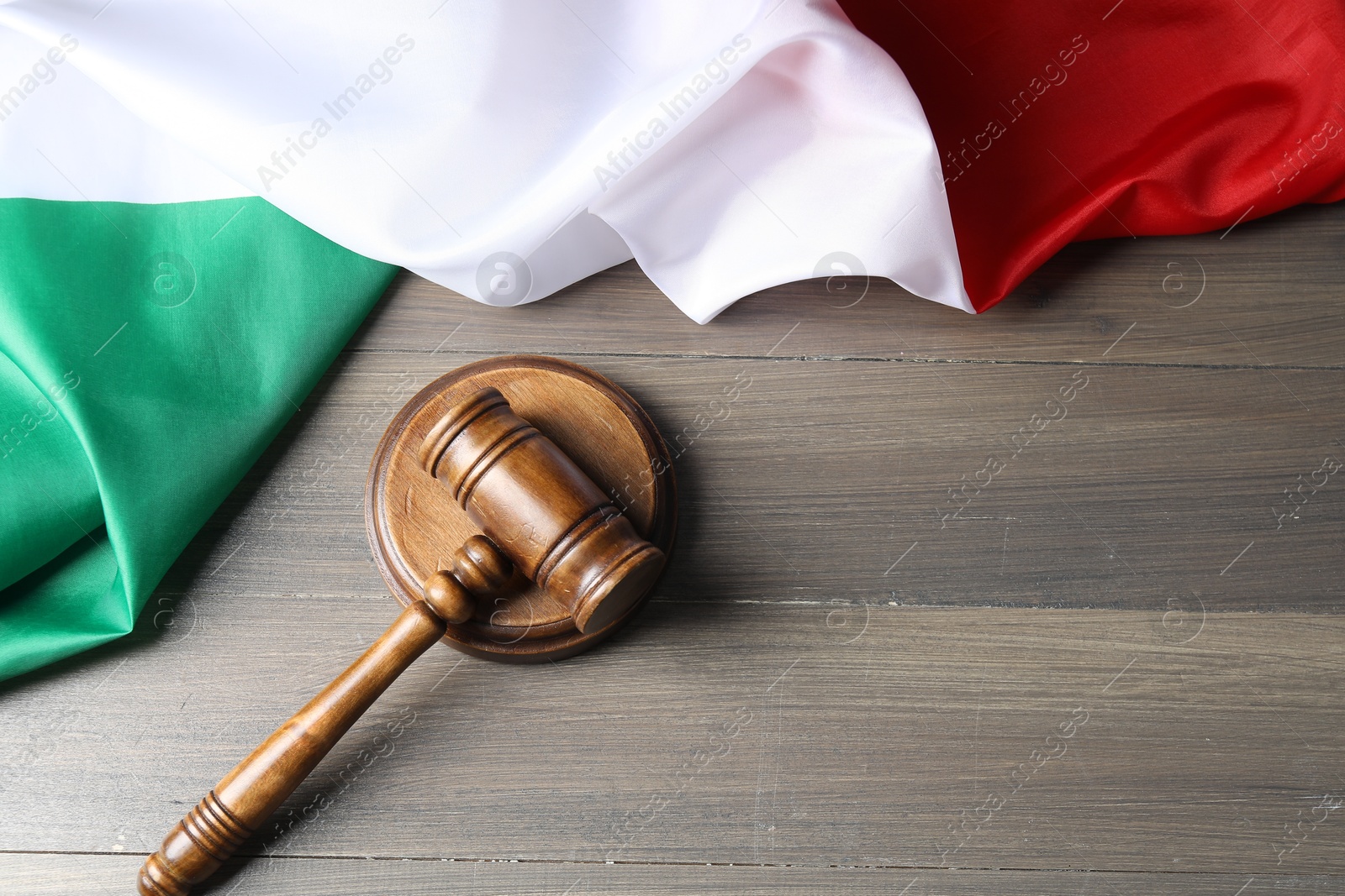 Photo of Judge's gavel and flag of Italy on wooden table, top view. Space for text