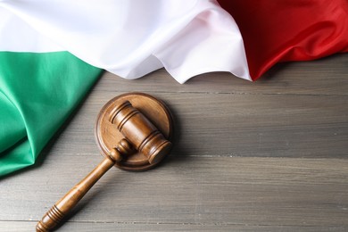Photo of Judge's gavel and flag of Italy on wooden table, top view. Space for text