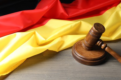 Photo of Judge's gavel and flag of Germany on wooden table