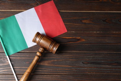 Photo of Judge's gavel and flag of Italy on wooden table, top view. Space for text