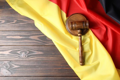 Photo of Judge's gavel and flag of Germany on wooden table, top view. Space for text