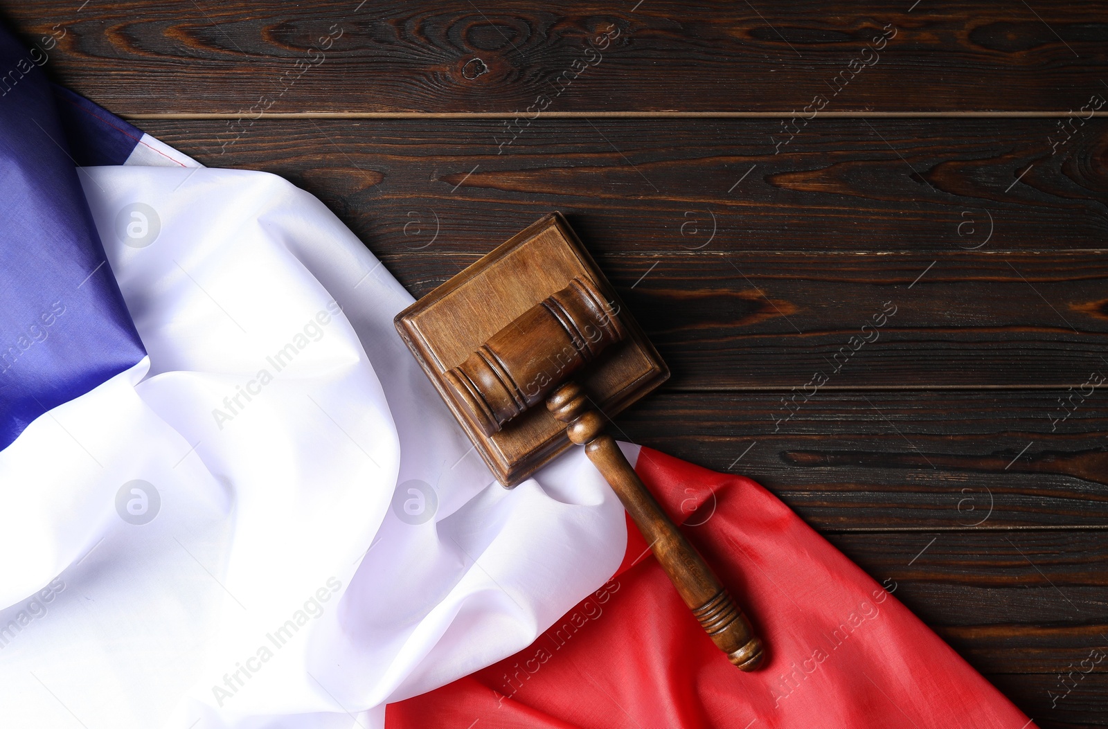 Photo of Judge's gavel and flag of France on wooden table, top view. Space for text