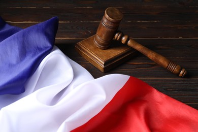 Photo of Judge's gavel and flag of France on wooden table