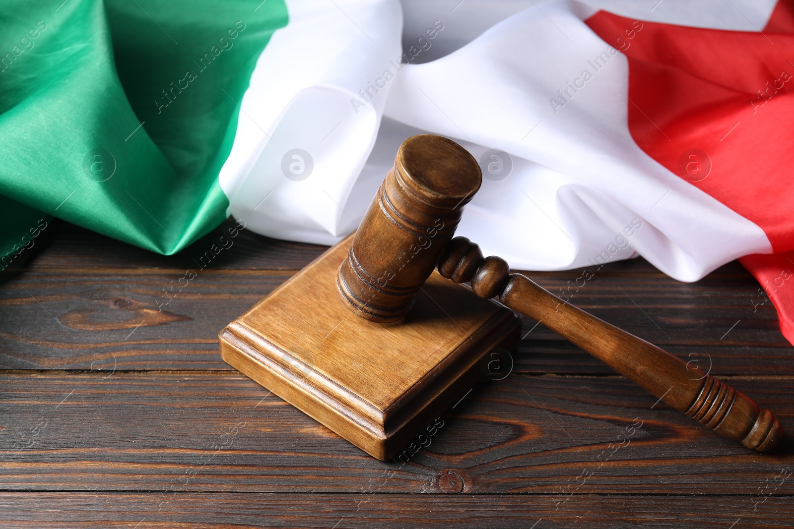 Photo of Judge's gavel and flag of Italy on wooden table