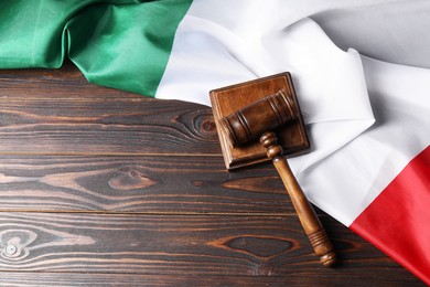 Photo of Judge's gavel and flag of Italy on wooden table, top view. Space for text